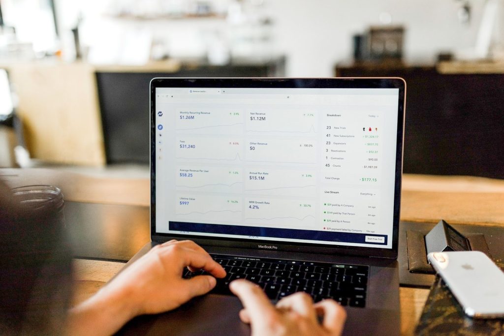 Small business owner reviewing digital invoices on a laptop to track payments.